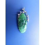 An oriental carved jadeite pendant in white metal with small diamonds, 1.5”