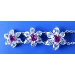 A ruby & diamond triple flowerhead cluster pendant necklace in white metal