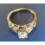 A diamond dress ring, the central claw set stone weighing approximately .75 carat with six small