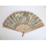 An early 19thC painted leaf fan, decorated in neoclassical taste with three elegant youths,