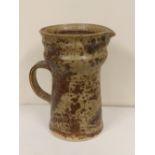 A studio pottery jug in mottled brown glaze – 'SB'