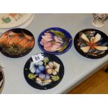 Three Moorcroft Collectors' Club circular dishes, 4.75” and an earlier blue ground floral dish (4)