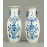 A large pair of Chinese blue and white vases, with flared rims, each decorated with vase on stand