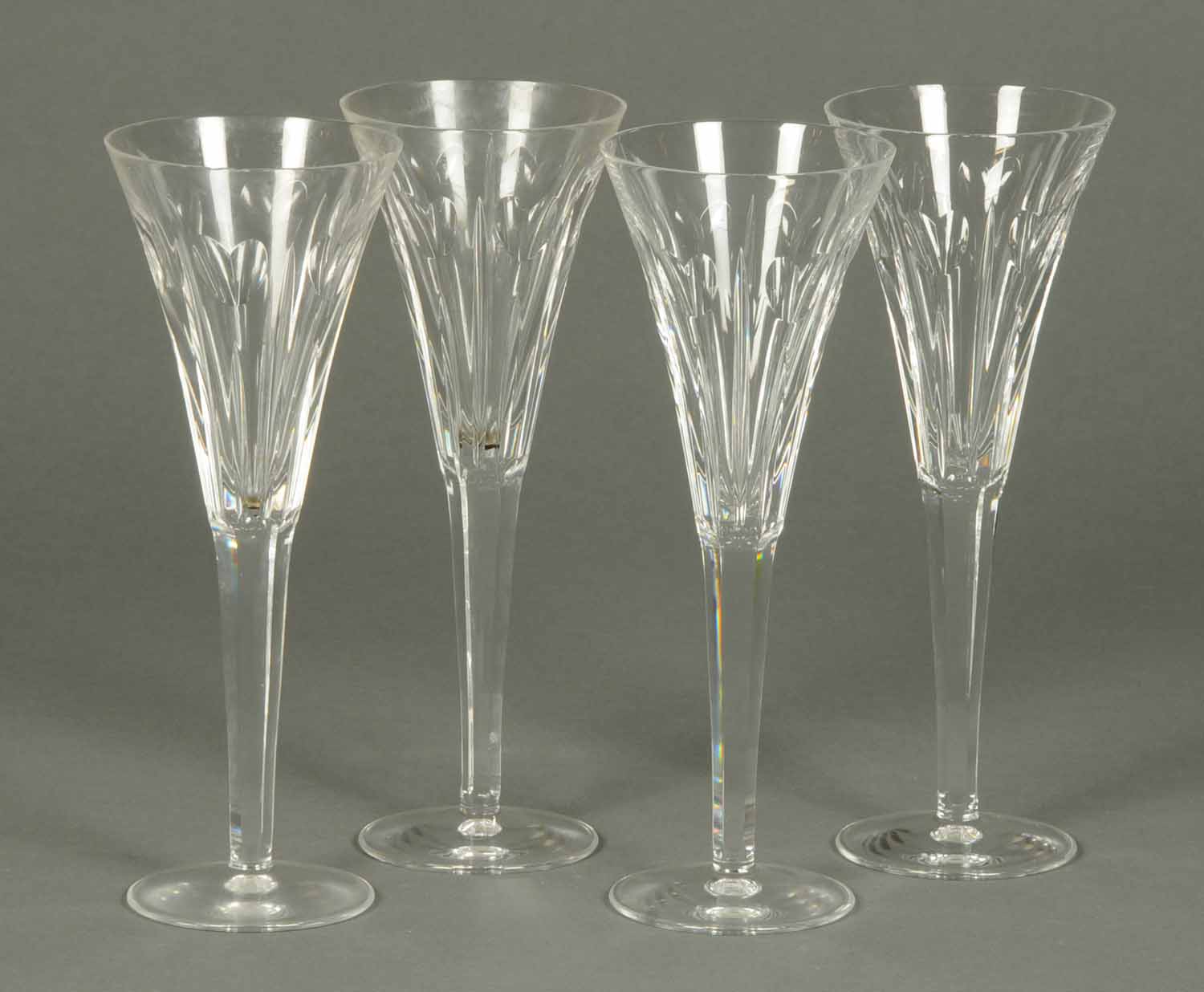 A set of four Waterford Crystal champagne flutes, each with faceted stem.  Height 9.25 ins.