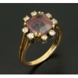 An amethyst and diamond ring, the emerald cut amethyst flanked by eight diamonds,