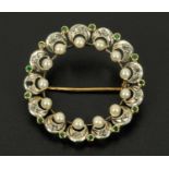 A Portuguese gold coloured metal brooch, circular, set with small pearls,