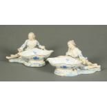 A pair of Continental porcelain table centres, in the form of a male and female holding baskets.