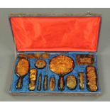 A cased simulated tortoiseshell dressing table set, with incised Chinoiserie motifs. CONDITION