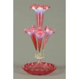 A Victorian cranberry glass epergne, with four flutes and shaped circular base.