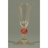 A late 18th century glass, with faceted body and knopped stem raised on a spreading circular