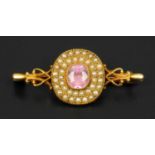 A Victorian gold coloured brooch, set with seed pearls and a pink stone.  Length 43 mm (see