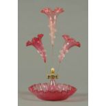 A Victorian cranberry glass epergne, three flutes and with pincered circular base.  Height 17.