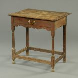 A Georgian oak lowboy, fitted with a frieze drawer, raised on turned legs united by stretchers.