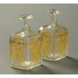 A pair of glass flasks, angled and faceted, stamped to base "Glasfabrik Karlsbad MM".  Height 18.