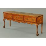 A George III oak dresser base, with moulded edge, three frieze drawers and raised on front