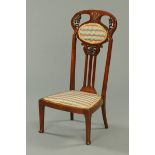 An Art Nouveau mahogany low chair, the back carved with stylised foliage, with moulded stiles,