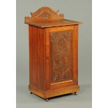 A late Victorian walnut music cabinet, with rear upstand and carved top,