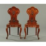 A pair of Victorian mahogany hall chairs, with shaped backs with applied carved mouldings,