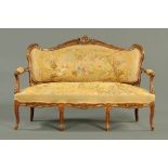 A Continental walnut settee, with exposed foliate carved scrolling showframe,