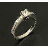 An 18 ct white gold ring, set with a princess cut diamond to centre and diamonds to each shoulder,