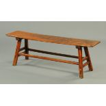 A 19th century elm long low table, raised on angled legs with stretchers between.  Length 142 cm,