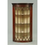 An early 20th century mahogany bowfronted corner cupboard,