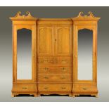 A Gillows of Lancaster oak breakfront wardrobe, fitted with a series of cupboards, drawers,