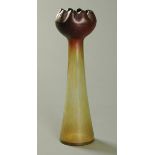 An iridescent glass hyacinth vase, amber and red, of inverted tapering form.  Height 34 cm.