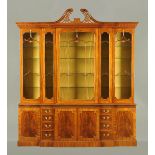 A George III style mahogany breakfront bookcase, hand carved, with swans neck pediment, egg, dart