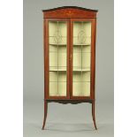 An Edwardian inlaid mahogany display case, with leaded glass doors and raised on splayed legs.