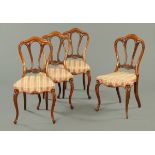 A set of four Victorian walnut dining chairs, with shaped carved backs,