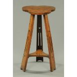 An Arts & Crafts oak occasional table, the top of shaped outline, with splayed supports and low