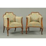 A pair of French carved walnut armchairs, with exposed moulded showframes and upholstered in foliate