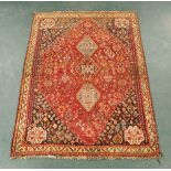 An Iranian woollen fringed rug, principal colours beige, red and blue.