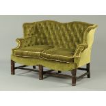 A Chippendale style settee, with deep buttoned back and arms,