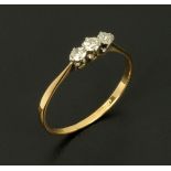 An 18 ct gold three stone diamond ring, size T.
