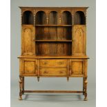 An early 20th century oak dresser, with moulded cornice above a series of shelves and cupboards,