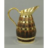 An oak barrel form jug, with brass loop handle and broad spout.  Height 52 cm.