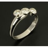 An 18 ct white gold twist set diamond ring, rubover set with three diamonds weighing approximately .