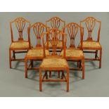 A set of six Hepplewhite style early 19th century rush seated elm dining chairs (see illustration).