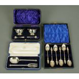 An Edwardian pair of open silver salts and spoons, cased, an Edwardian set of six silver teaspoons,