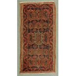 * A Persian rug, with red ground, decorated in dark blue and beige and with repeating line border.