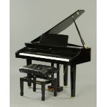 A Roland HP-11 digital baby grand piano, in piano black with matching adjustable music seat.