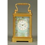 A miniature brass carriage clock, with blue foliate and bird patterned porcelain panels,