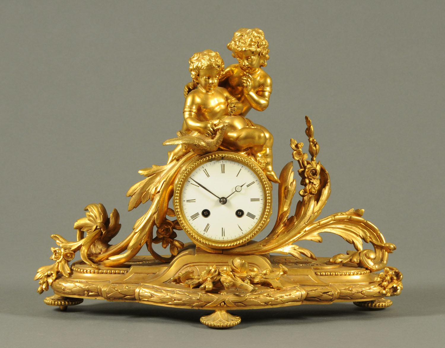 A 19th century French ormolu clock, with children and exotic bird surmount,