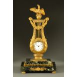 A French Empire gilt lyre clock, raised on a marble base.  Height 36 cm.