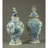 Two 18th century Delft vases, lidded, one decorated with a bird the other with flowers in vase.