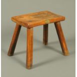 A fruitwood country milking stool, bearing label "Burgess & Colbourne".  Width 33 cm.