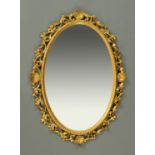 A late 19th century Venetian gilt framed oval mirror, in the Rococo style.