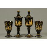 A pair of 19th century Bohemian amber glass goblets, and pair of similar lidded vessels,